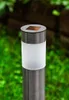 A close-up of a solar-powered garden light in a garden setting. Podgląd zdjęcia produktu