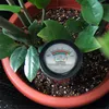 A soil moisture and pH meter is inserted into the soil of a potted plant. Produktbild-Vorschau