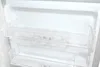The interior of an empty refrigerator with clear plastic shelves. Produktbild-Vorschau