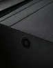A close-up view of a black sink with a circular detail on its side. Podgląd zdjęcia produktu