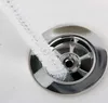 A white cleaning brush is being used to clean a sink drain. Produktbild-Vorschau