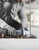 A person is using an angle grinder to cut metal, with sparks flying. Produktbild-Vorschau