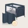 A navy blue travel crib with a star pattern on the top edge and a foldable blue mat in front of it. A circular icon with a hand wiping a surface is in the lower right corner. Anteprima dell’immagine prodotto