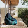 A bean bag chair with a binary code pattern is placed on a wooden deck next to a small round table. Voir les images du produit