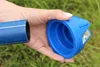 A hand holding a blue pipe and a blue pipe chamfering tool. Voir les images du produit