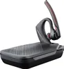 A black and gray Plantronics Voyager 5200 headset with a charging base, isolated on a white background. Produktbild-Vorschau