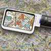 A magnifying glass with LED light is placed on a map, highlighting a section of a city. Produktbild-Vorschau