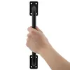 A hand is holding a black door handle against a white background. Produktbild-Vorschau