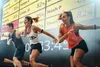 People participating in a fitness class in front of a large screen displaying scores and a timer. Náhled obrázku produktu