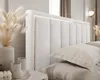 A close-up view of a white upholstered bed with gold trim and a lit headboard. Produktbild-Vorschau