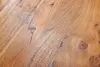 A close-up view of a wooden surface, showing the natural grain and texture of the wood. Produktbild-Vorschau