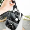 A hand is placing knives into a utensil holder, which also contains forks and spoons. Produktbild-Vorschau