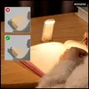 A person is writing in a book with a clip-on LED reading light attached to the book. Náhľad obrázku produktu