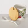 A ceramic jar with a strawberry design, a wooden lid, and a spoon. Produktbild-Vorschau