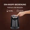 A hand is pressing the button on a Turkish coffee maker, with text describing its features. Produktbild-Vorschau