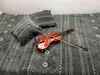 A violin and bow are placed on a gray blanket with a patterned design, next to two pillows. Anteprima dell’immagine prodotto