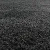 A close-up, angled view of a dark gray shaggy rug. Produktbild-Vorschau