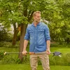 A man stands in a garden holding a long-handled pruning tool. Produktbild-Vorschau