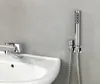 A close-up view of a sink faucet and a handheld bidet sprayer mounted on a gray wall. Podgląd zdjęcia produktu