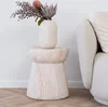 A decorative side table with a vase of flowers next to a sofa. Podgląd zdjęcia produktu