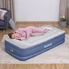 A woman sleeps on an inflatable mattress in a room. Produktbild-Vorschau