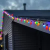 Colorful Christmas lights strung along the roofline of a house. Produktbild-Vorschau
