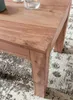 Close-up of a wooden table leg and corner on a patterned rug. Anteprima dell’immagine prodotto