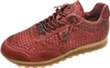 A single red leather sneaker with perforations and a tan sole, shown against a white background. Voir les images du produit