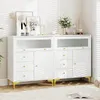 A white dresser with gold accents and decorative items on top, set against a white wall with blinds casting shadows. Podgląd zdjęcia produktu