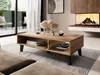 A modern living room with a wooden coffee table in the foreground, a fireplace in the background, and a view of an outdoor patio through large glass doors. Voir les images du produit