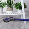 A vacuum cleaner head on a carpet in front of a white shelf with potted plants. Produktbild-Vorschau