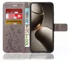 A close-up view of a grey flip phone case with a floral design, showing credit cards and euro banknotes inserted into its compartments, and a smartphone screen displaying abstract shapes. Produktbild-Vorschau
