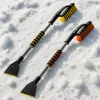 Two snow brushes with ice scrapers are lying on a surface of snow. Produktbild-Vorschau