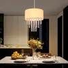 A dining room setting with a chandelier hanging over a table set for a meal. Náhľad obrázku produktu