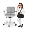 A young girl dressed in school attire stands next to a gray ergonomic desk chair. Voir les images du produit