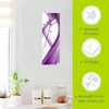 A wall clock with a purple abstract design is displayed on a white wall above kitchen canisters. To the right, a green panel highlights product features with icons and text. Produktbild-Vorschau