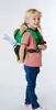A young girl wearing a backpack with a stuffed animal attached. Náhľad obrázku produktu