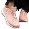 A pair of pink sneakers worn by a person, shown from a slightly elevated angle.