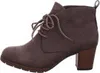 A side view of a brown lace-up ankle boot with a block heel. Voir les images du produit