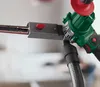 Close-up of a power tool attachment with a sanding belt and a vacuum hose. Produktbild-Vorschau