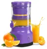 A purple electric citrus juicer is shown with oranges and freshly squeezed orange juice. A glass of orange juice is splashing. Podgląd zdjęcia produktu