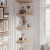 A corner shelf unit displaying decorative items and books, next to a window. Voir les images du produit