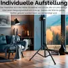 A living room setting with a sofa, a heater on a tripod, and a window view of trees. Produktbild-Vorschau