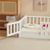 A white wooden children's bed with a guardrail and a flower-shaped pillow. Náhľad obrázku produktu