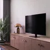 A TV stand with a TV, lamp, and plant in a living room setting. Produktbild-Vorschau
