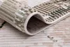 A close-up view of a rolled-up rug, showing the texture and pattern of the material. Produktbild-Vorschau