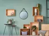 A collection of wooden storage boxes and decorative items arranged on a light green wall. Produktbild-Vorschau
