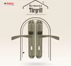 A pair of bronze-colored door handles displayed within an arched frame, with text and a logo above. Produktbild-Vorschau