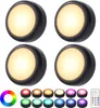 Four LED puck lights are arranged in a 2x2 grid on a white background. Below the lights are color swatches and a remote control. Produktbild-Vorschau