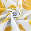 A close-up view of a rolled-up fabric with a yellow abstract pattern on a white background. Produktbild-Vorschau